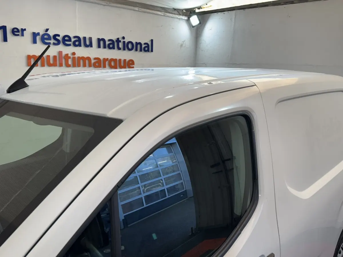 Vue de côté droit sur le haut d’un Citroën Berlingo blanc utilitaire avec antenne sur le toit et vitre avant teintée.