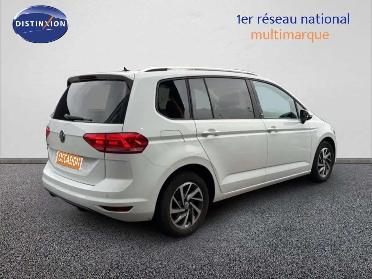 Vue 3/4 arrière droite d'un Volkswagen Touran blanc 2018 avec jantes alliage et feux arrière LED.