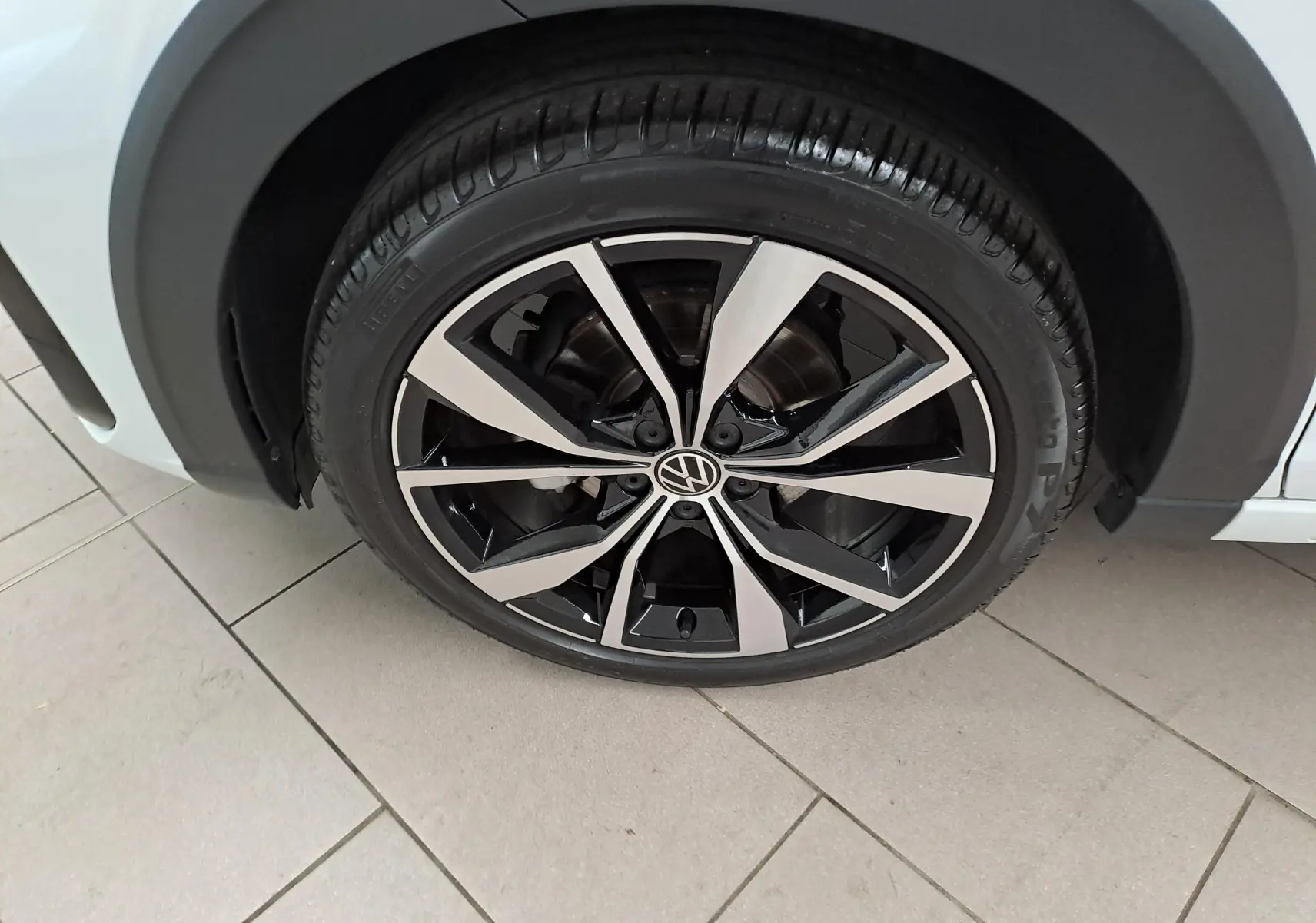 Gros plan sur la jante alliage 18 pouces bicolore du Volkswagen Taigo blanc pur avec toit noir, version R-Line Edition 2025.