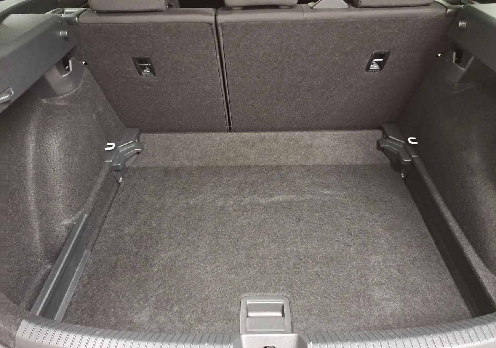 Coffre vide vu de l'arrière d'un Volkswagen Taigo 1.5 TSI 150 DSG7 R-Line Edition, intérieur noir.