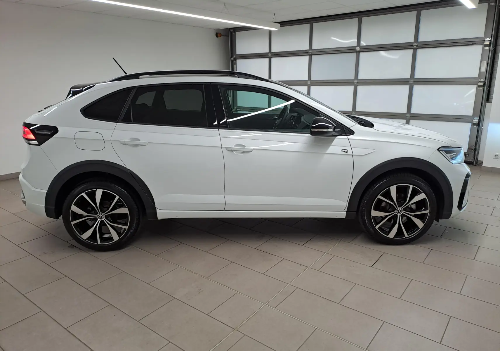 Vue latérale droite du Volkswagen Taigo 1.5 TSI 150 DSG7 R-Line Edition blanc pur avec toit noir et jantes alliage 18 pouces.