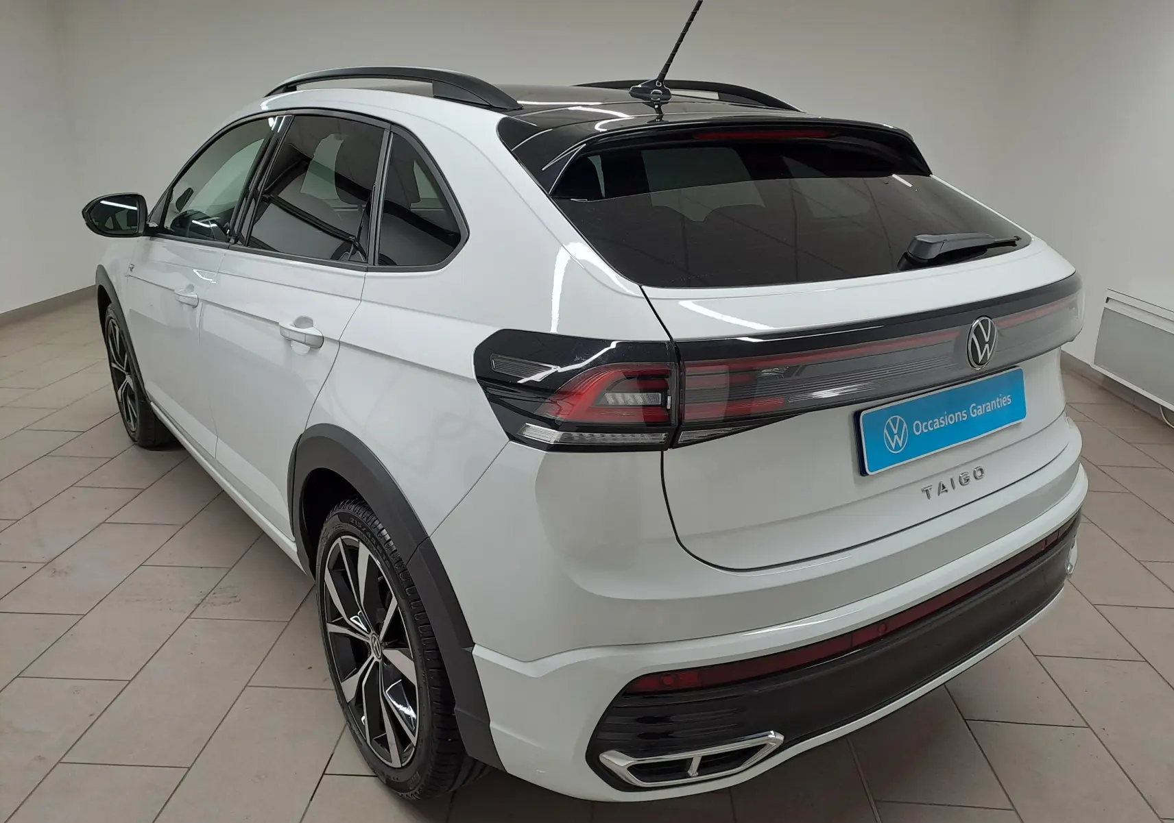 Vue 3/4 arrière droite du Volkswagen Taigo blanc pur avec toit noir et jantes alliage 18 pouces Misano.