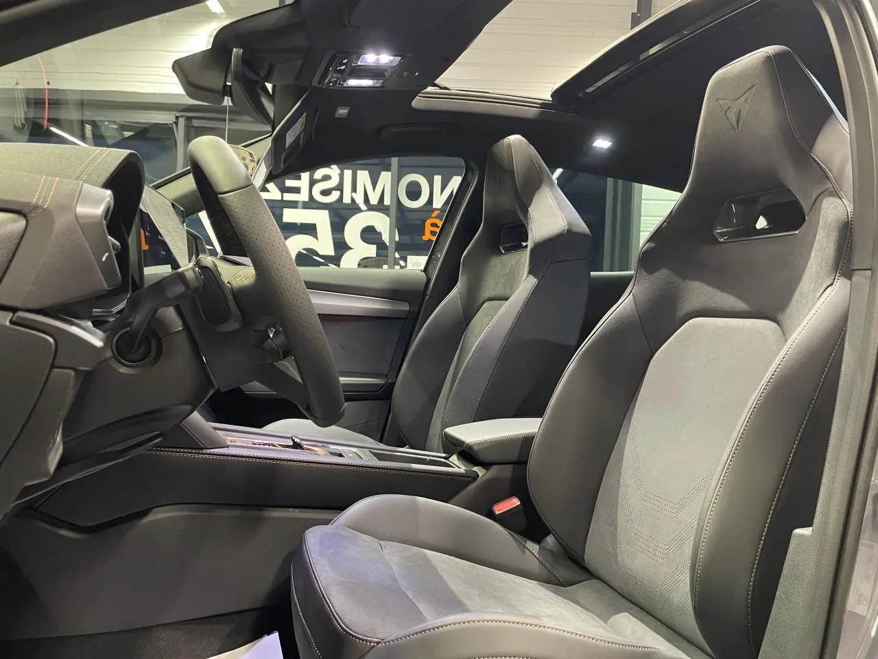 Vue intérieure côté gauche du CUPRA Formentor gris Graphene, sièges baquets suédine noire avec surpiqûres cuivrées et logo Cupra.