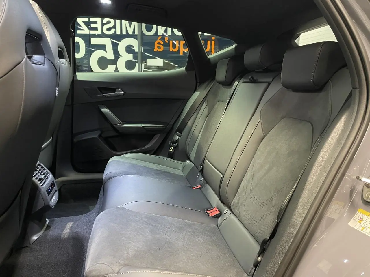 Vue côté droit de la banquette arrière en suédine noire et cuir du CUPRA Formentor gris Graphene, avec ceinture et appuie-têtes.