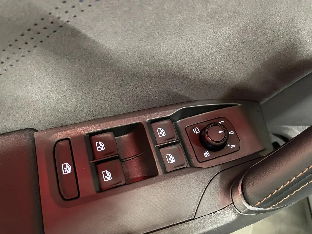 Détail des commandes de lève-vitres et réglage des rétroviseurs sur la contre-porte suédine noire du Cupra Formentor gris Graphene.