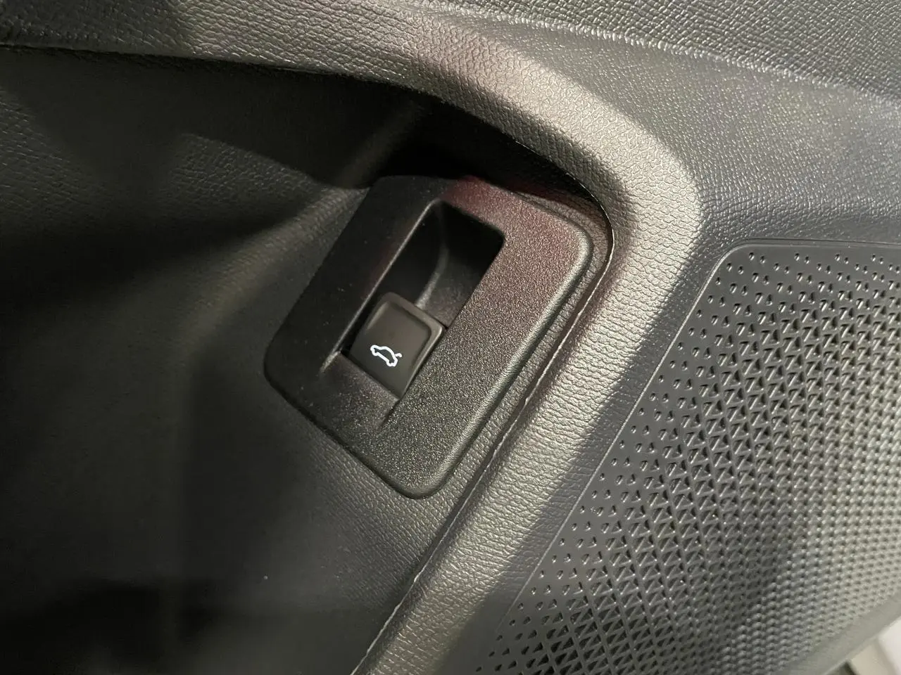Détail du bouton d'ouverture du hayon sur la contre-porte intérieure noire du CUPRA Formentor gris Graphene.