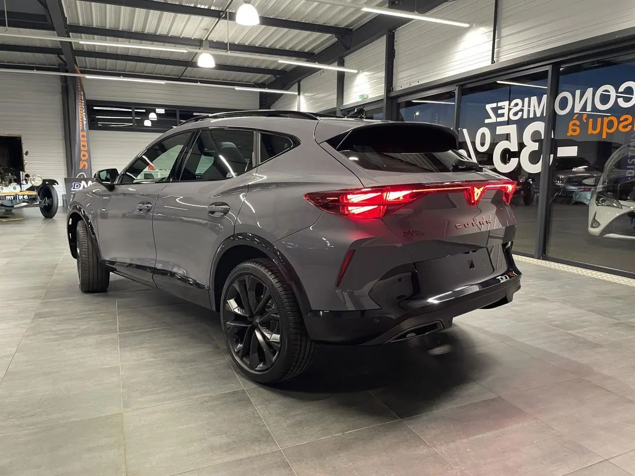 Vue 3/4 arrière droite d’un CUPRA Formentor gris Graphene avec feux arrière Tri-LED et jantes alliage noires.