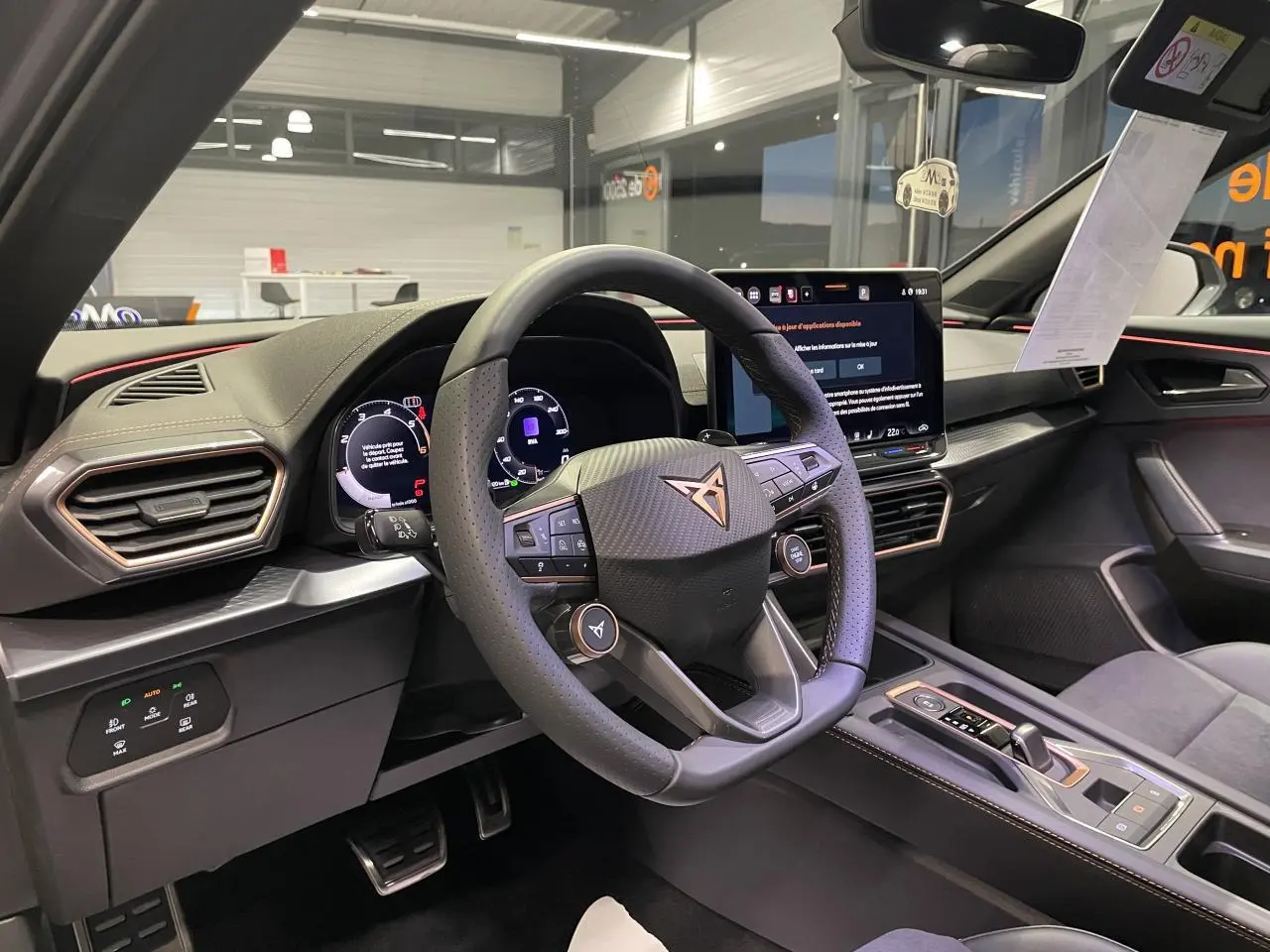 Vue intérieure du poste de conduite du CUPRA Formentor 2026, volant cuir perforé avec logo cuivré et écran tactile central.