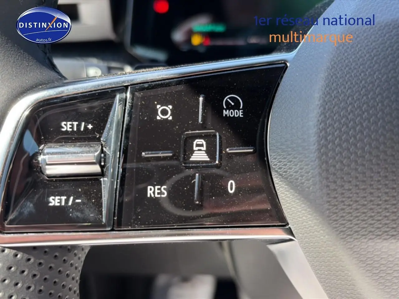 Gros plan sur les commandes du volant noir de la Renault Clio VI 1.2 TCe 115 Techno EDC, avec boutons de régulateur et mode de conduite.