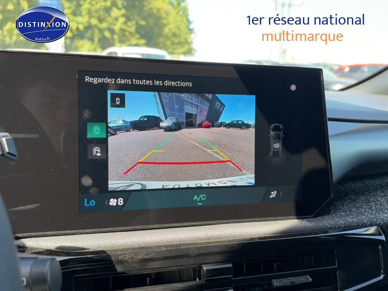 Écran multifonction de la Renault Clio VI noir montrant la caméra de recul avec guidage coloré en stationnement.