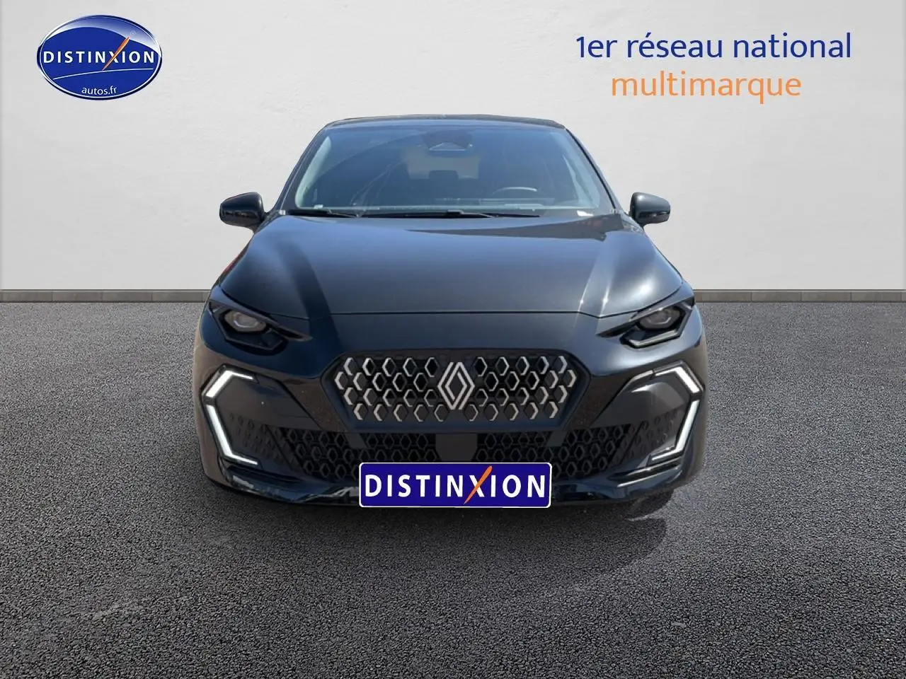 Vue frontale d'une Renault Clio VI noire 2026 avec calandre hexagonale et feux LED en forme de C.