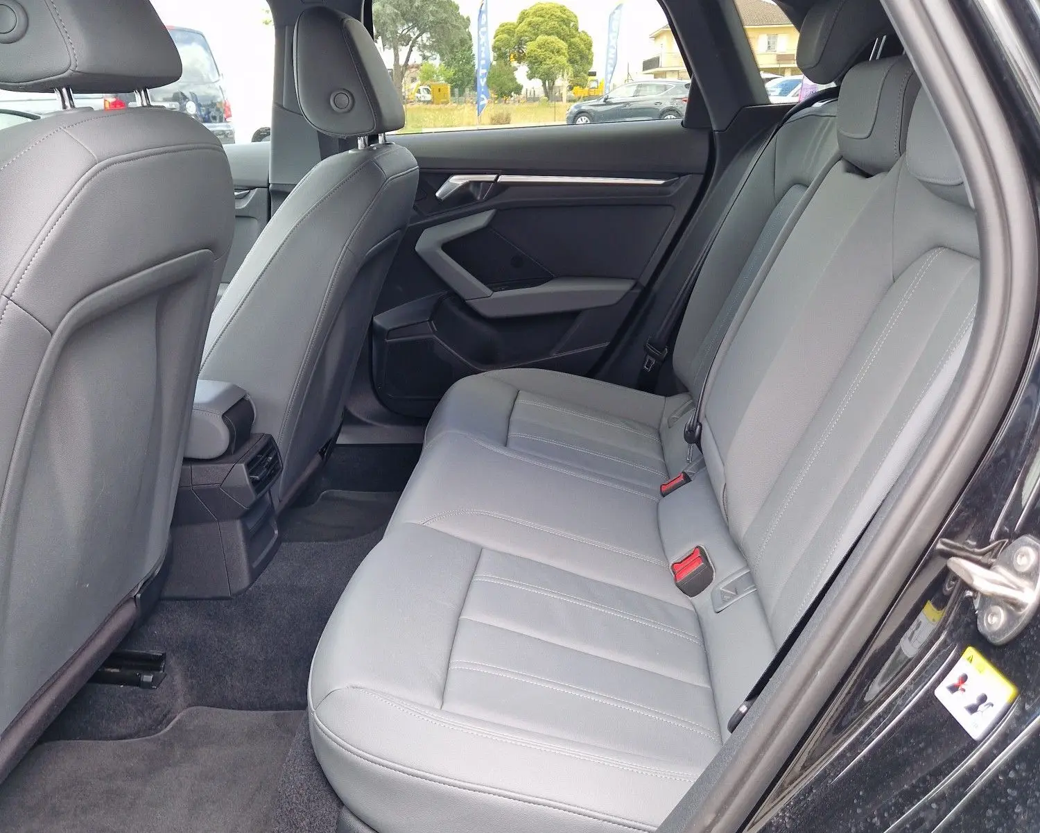 Vue intérieure côté droit des sièges arrière gris clair d'une Audi A3 Sportback noire, avec détails modernes et espace généreux.