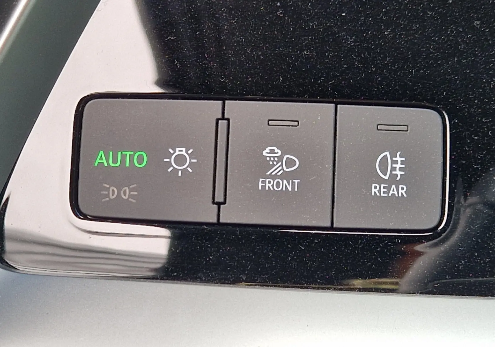 Gros plan sur les boutons de commande d'éclairage automatique et antibrouillard avant/arrière dans l'habitacle noir de l'Audi A3 Sportback.