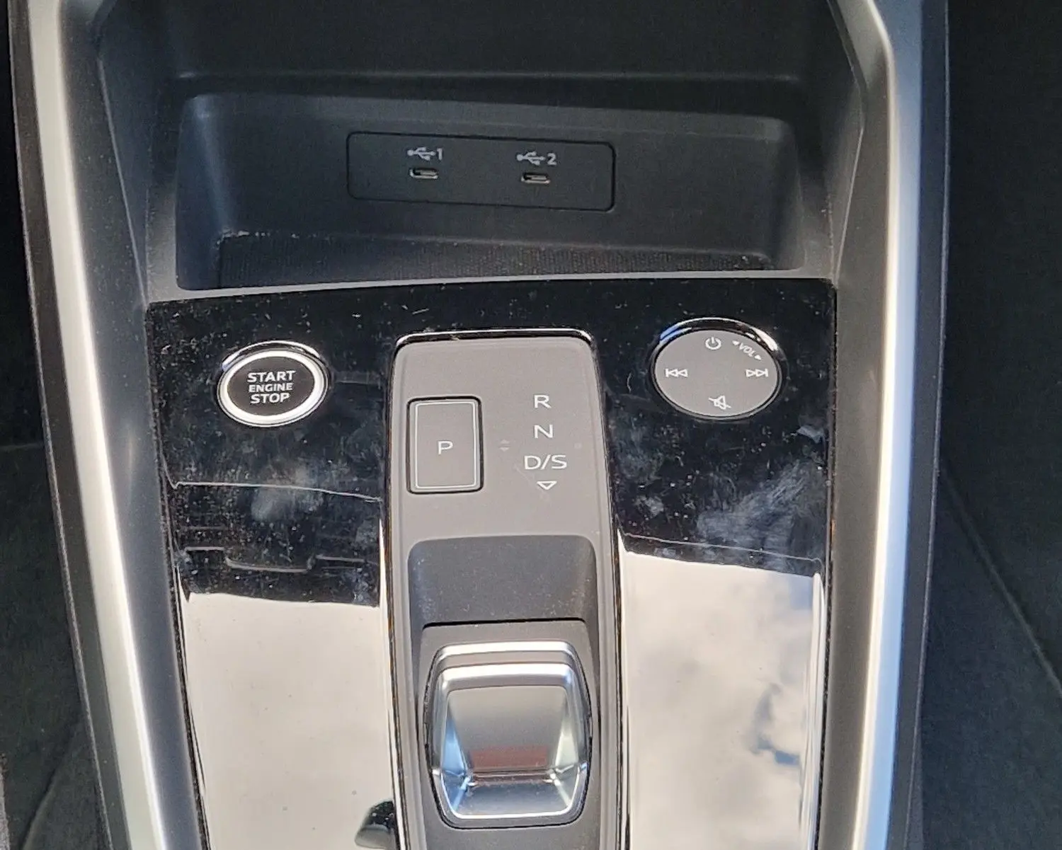 Vue rapprochée de la console centrale noire de l’Audi A3 Sportback 40 TFSI-e avec levier de vitesse automatique et boutons de contrôle.