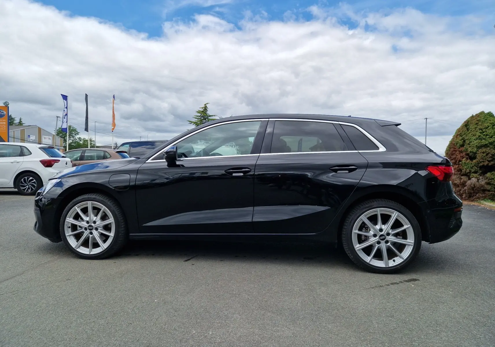 Audi A3 Sportback noir vue de profil côté gauche, soulignant ses jantes alliage et lignes épurées.