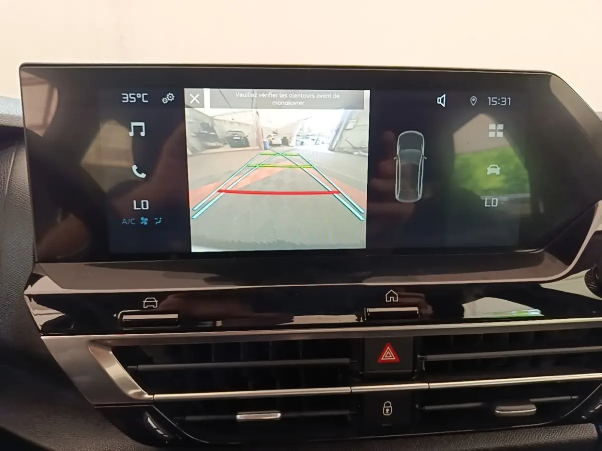Écran tactile central du tableau de bord du Citroën C4 X noir, affichant la caméra de recul et les aides au stationnement.