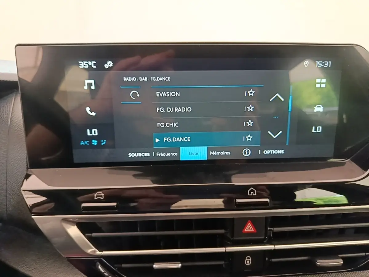 Vue rapprochée de l’écran tactile central du tableau de bord de la Citroën C4 X 2023 affichant les options radio et climatisation.