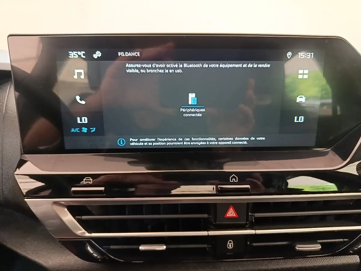 Vue rapprochée de l’écran tactile central noir du tableau de bord de la Citroën C4 X 2023 avec affichage multimédia et climatisation.