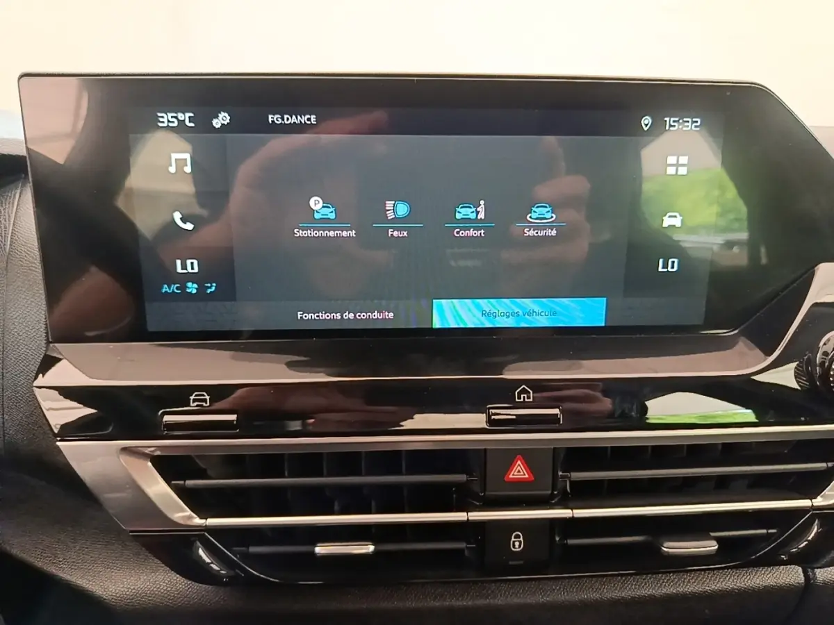 Écran tactile central du tableau de bord de la Citroën C4 X 2023 avec commandes climatisation et fonctions de conduite affichées.