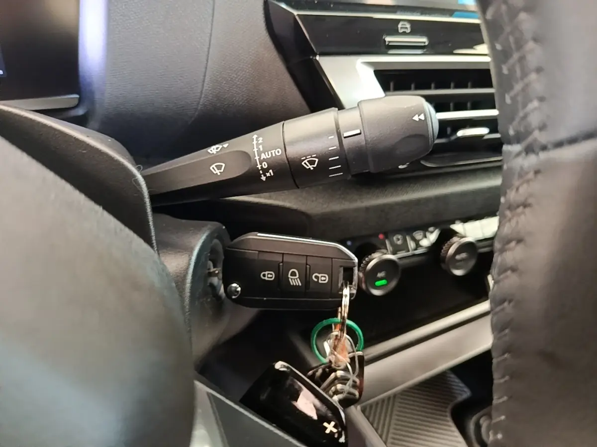 Gros plan sur la clé insérée dans le contacteur côté gauche du tableau de bord noir de la Citroën C4 X 2023.