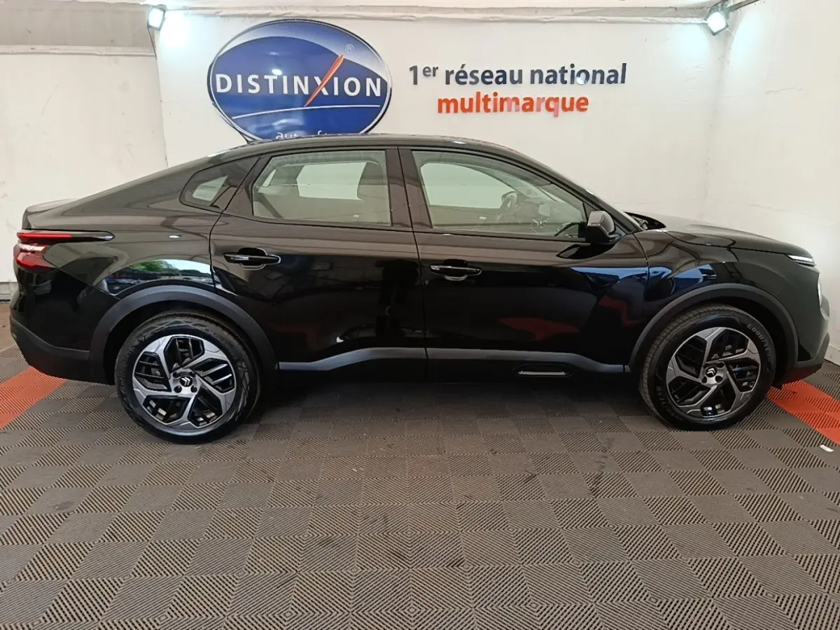 Profil côté gauche d'une Citroën C4 X noire 2023, finition Feel Pack, avec jantes alliage et feux arrière LED distinctifs.