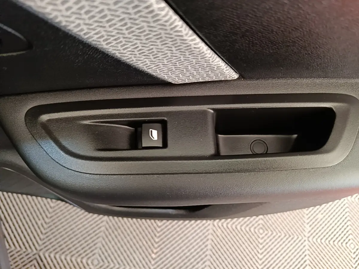 Gros plan sur la commande de lève-vitre côté porte intérieure d'une Citroën C4 X noire, version 2023.
