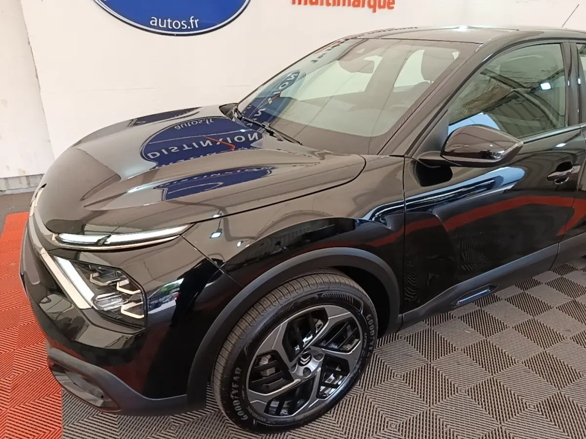 Vue 3/4 avant droit d'une Citroën C4 X noire avec phares LED et jantes alliage noires.