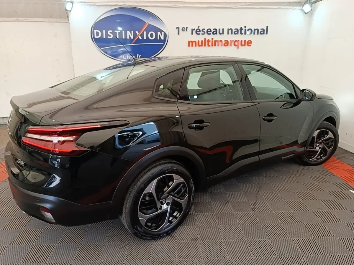 Vue 3/4 arrière droite d'une Citroën C4 X noire 2023 avec feux LED distinctifs et jantes alliage modernes.