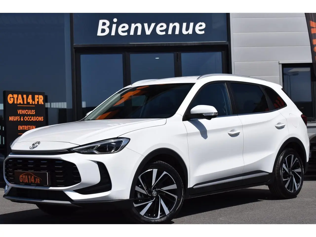 MG ZS 2026 blanc en 3/4 avant droit, SUV hybride avec jantes alliage 18 pouces et calandre noire distinctive.