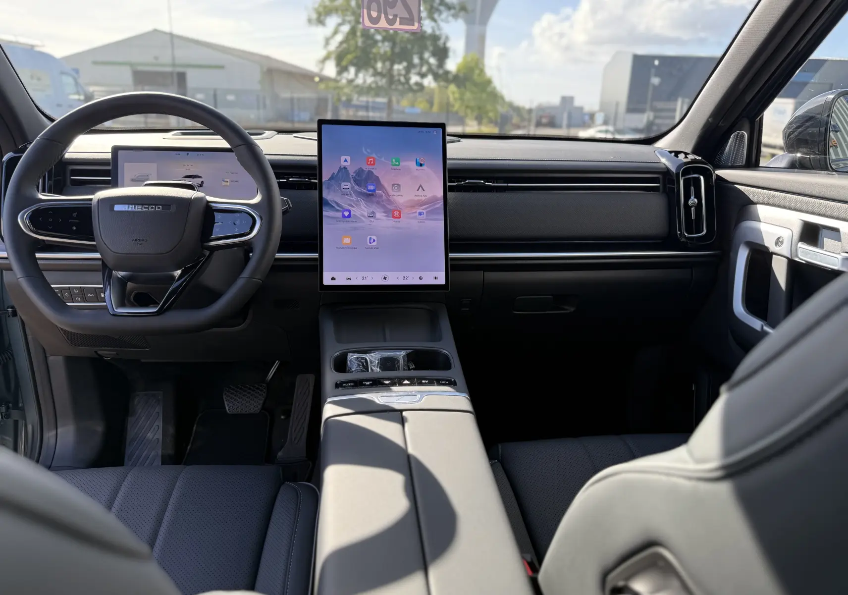 Vue intérieure avant du JAECOO J7 PHEV 279 CH en argent, avec grand écran tactile vertical et volant multifonction.