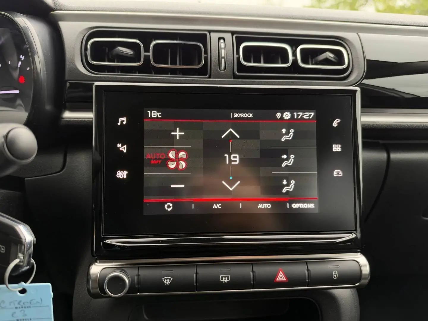 Vue rapprochée de l’écran tactile central et des commandes de climatisation d’une Citroën C3 blanche Banquise 2024.