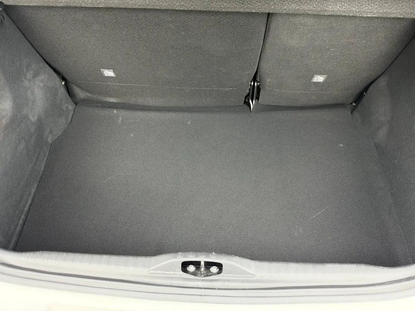 Coffre ouvert vu de face d’une Citroën C3 1.2 PureTech 110ch blanc Banquise, intérieur noir et tapis propre.