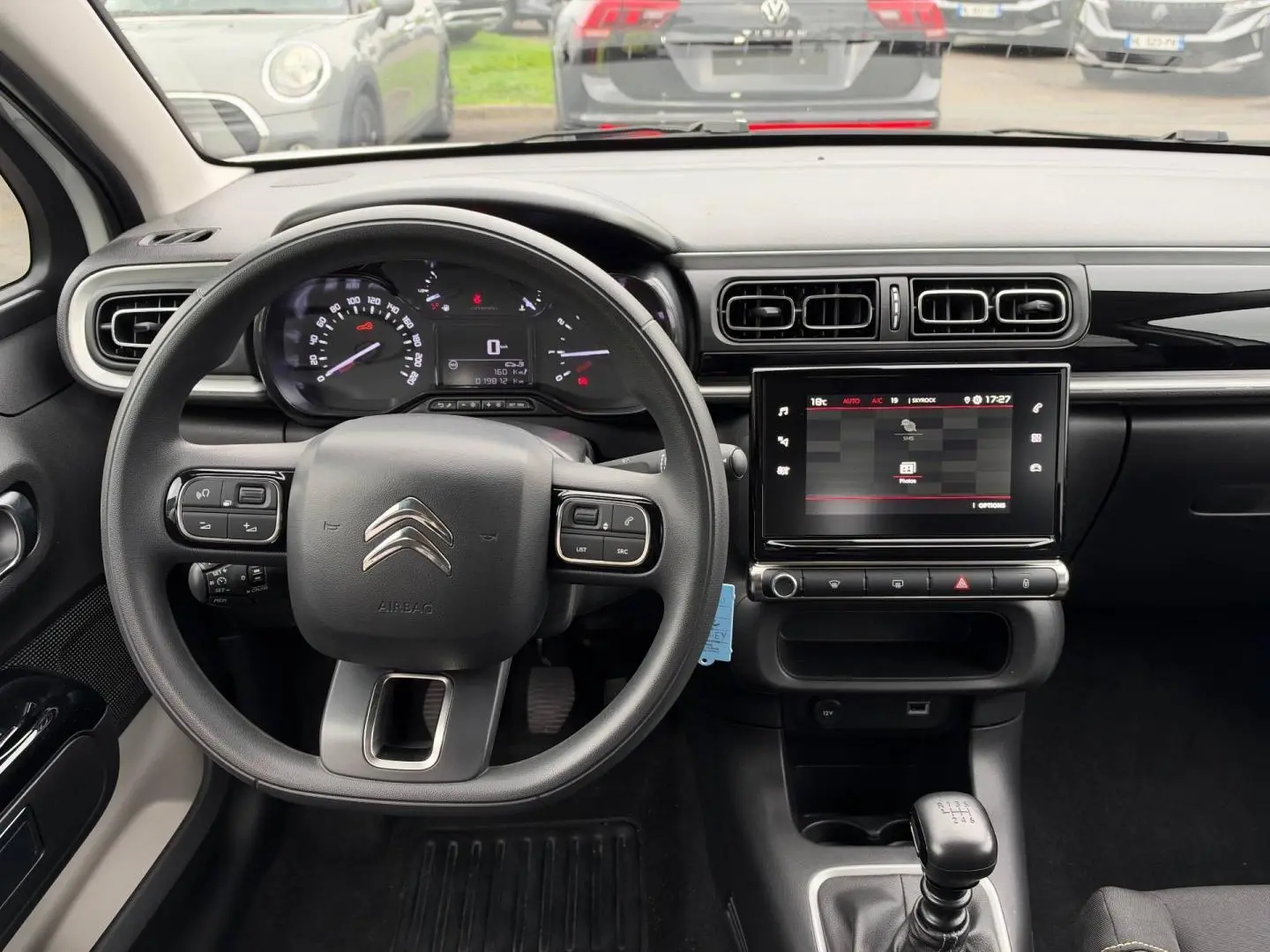 Vue intérieure avant du tableau de bord de la Citroën C3 blanche, avec volant multifonction et écran tactile central.