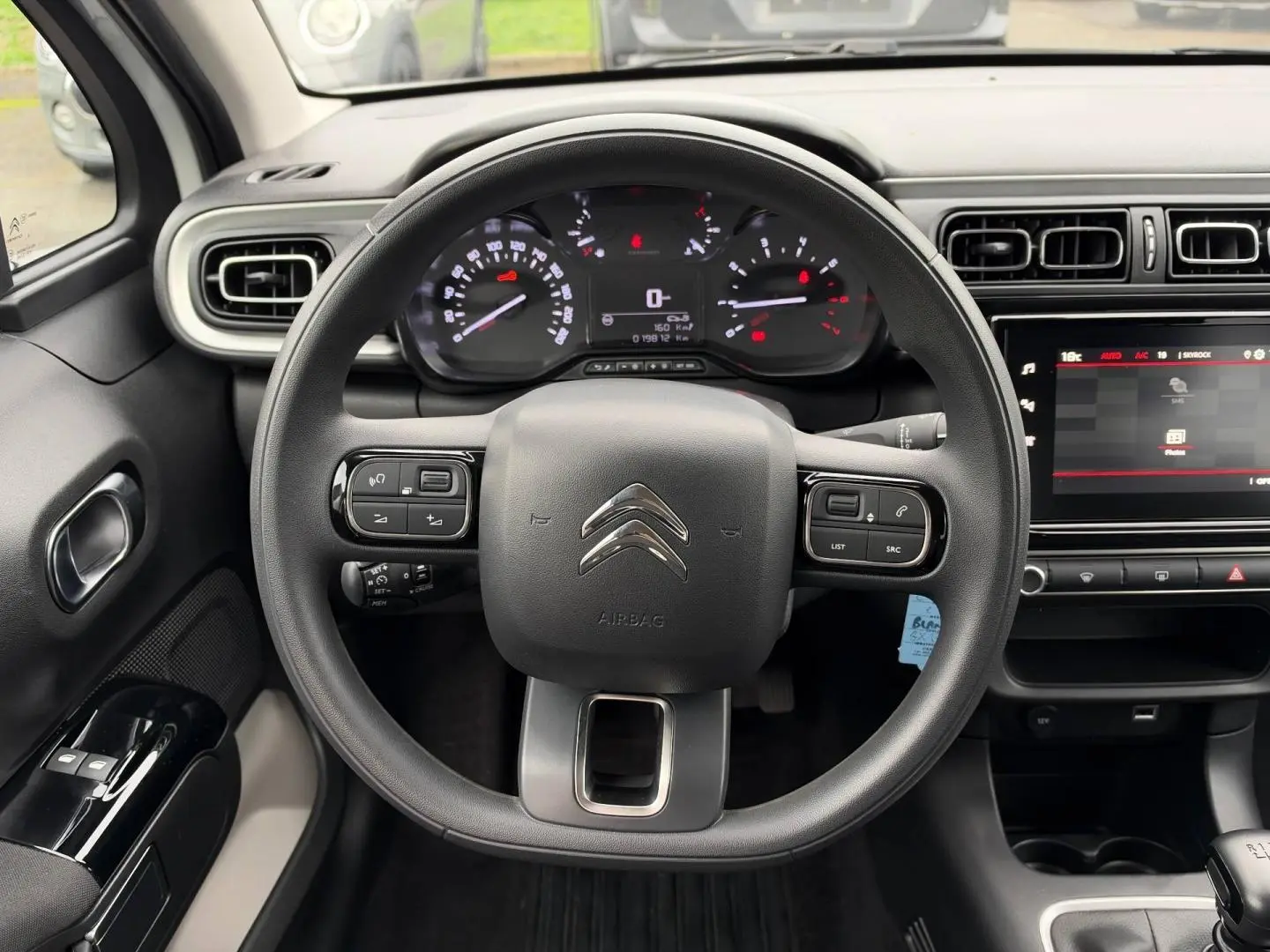 Vue intérieure centrée sur le volant noir de la Citroën C3 2024 avec tableau de bord et écran tactile.