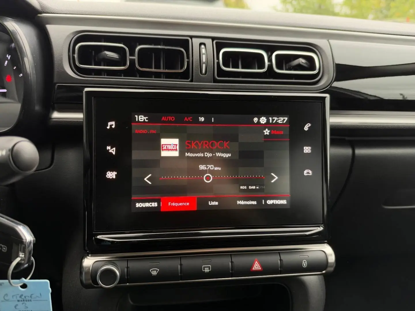 Vue rapprochée de l’écran tactile central de la Citroën C3 2024 affichant la radio Skyrock, entouré de commandes et aérateurs noirs.