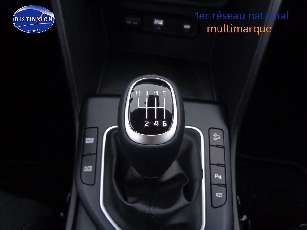 Gros plan sur le levier de vitesse manuel noir de la KIA SPORTAGE 1.6 T-GDI 2022, entouré de boutons de commande.