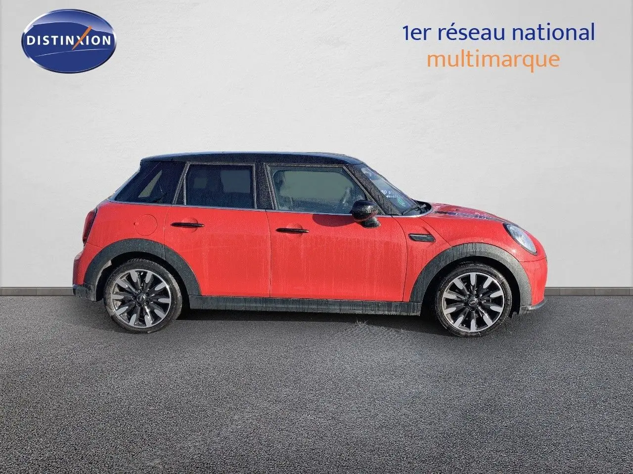 Profil côté gauche d'une MINI 1.5 136CH Steptronic rouge chili avec toit noir et jantes bi-ton 17 pouces.