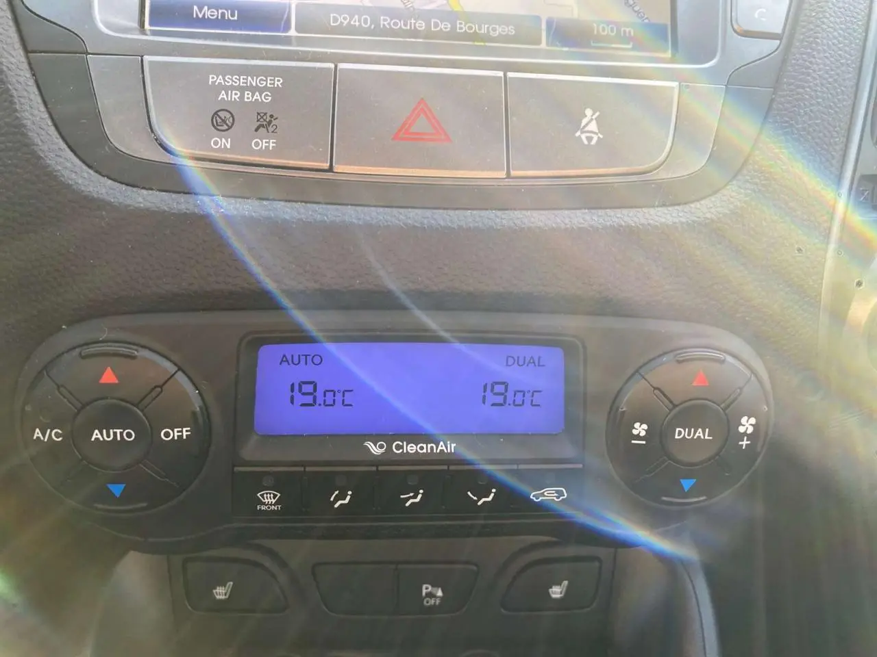 Gros plan sur la console centrale du Hyundai ix35 blanc 2014, affichant la climatisation automatique bi-zone à 19°C.