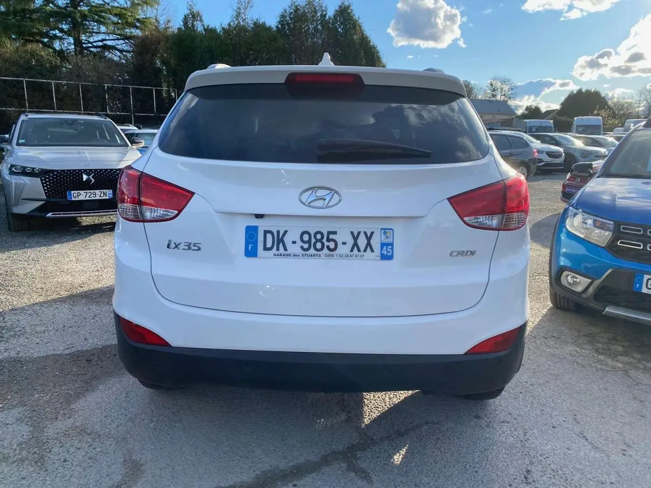 Vue arrière d'un Hyundai ix35 blanc diesel de 2014, avec logo et plaques visibles sur un parking ensoleillé.