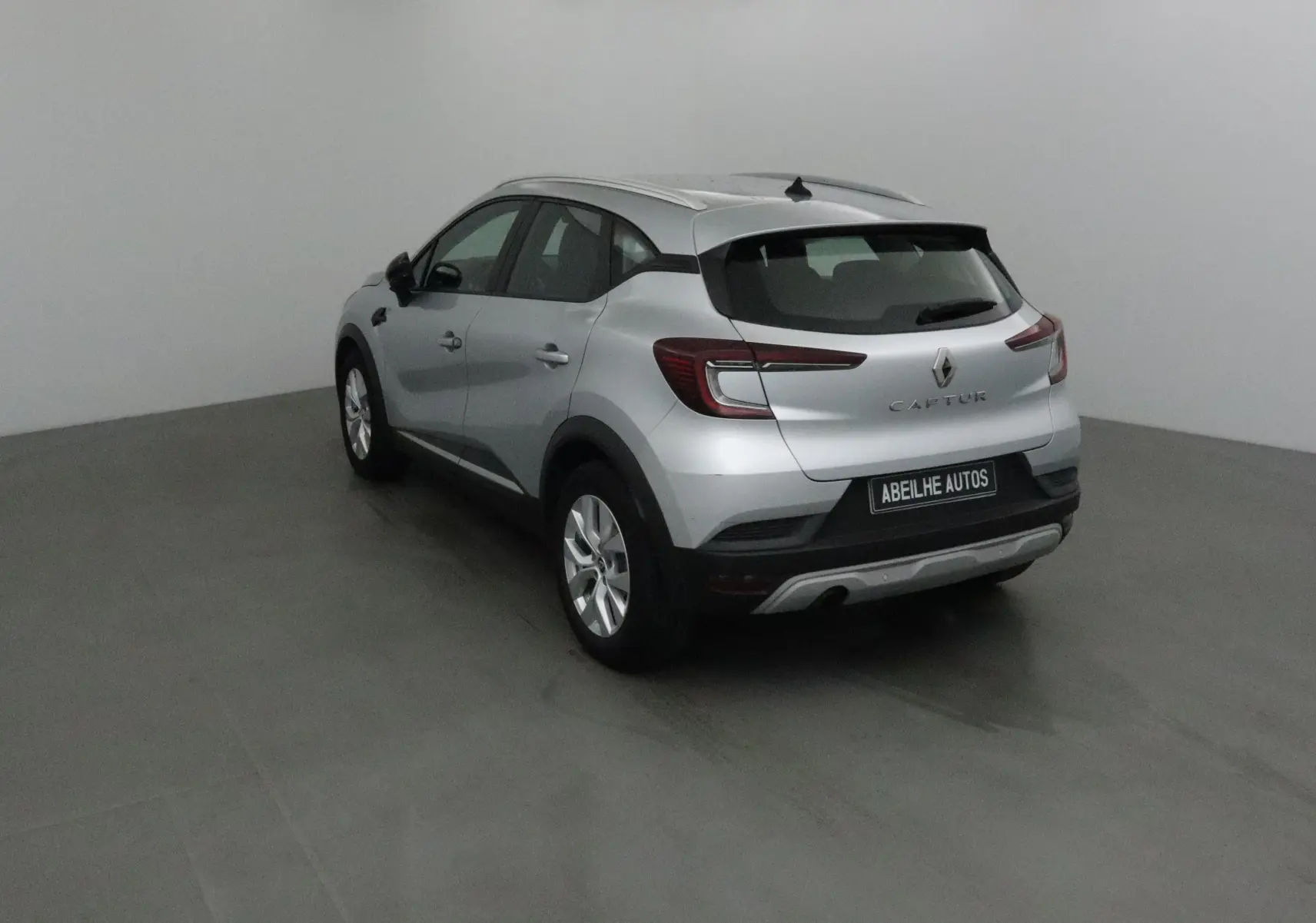 Vue 3/4 arrière droite d'un Renault Captur gris Highland 2020 avec feux arrière LED et jantes alliage 17 pouces.
