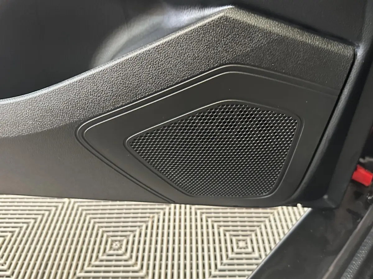 Gros plan sur le haut-parleur intégré à la porte côté conducteur de l'AIXAM AMBITION 0.5 CITY SPORT rouge 2026.