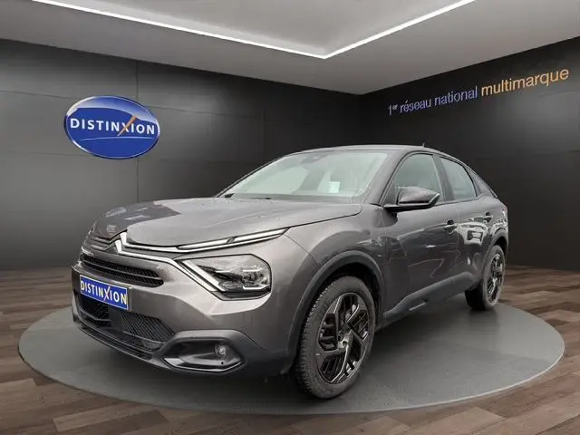 Vue 3/4 avant d'une Citroën C4 gris platinium 2022, avec phares LED et jantes alliage noires distinctives.