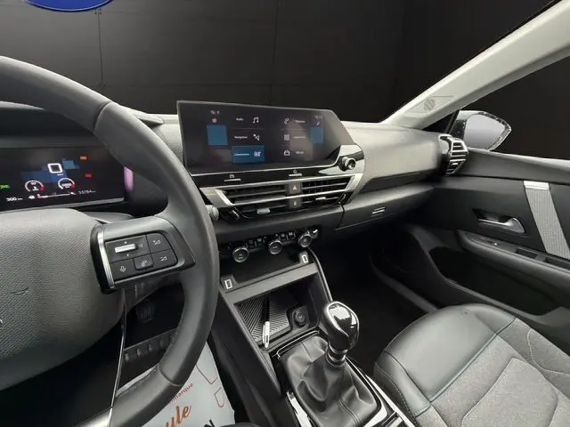 Intérieur côté conducteur de la Citroën C4 gris platinium 2022, avec tableau de bord numérique et boîte manuelle.