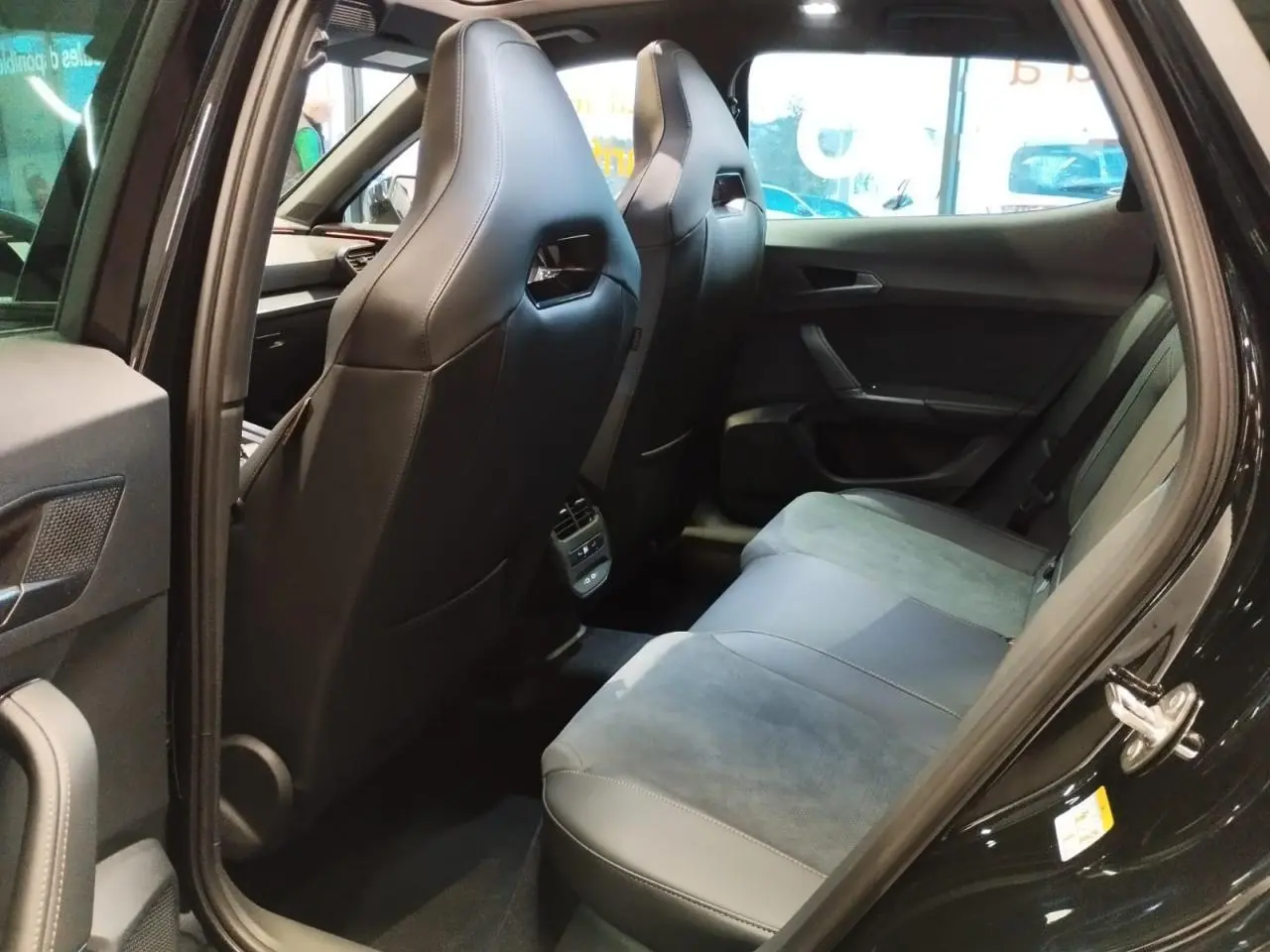 Vue intérieure arrière côté gauche du CUPRA Formentor noir métal, montrant les sièges baquets en suédine et cuir noir.