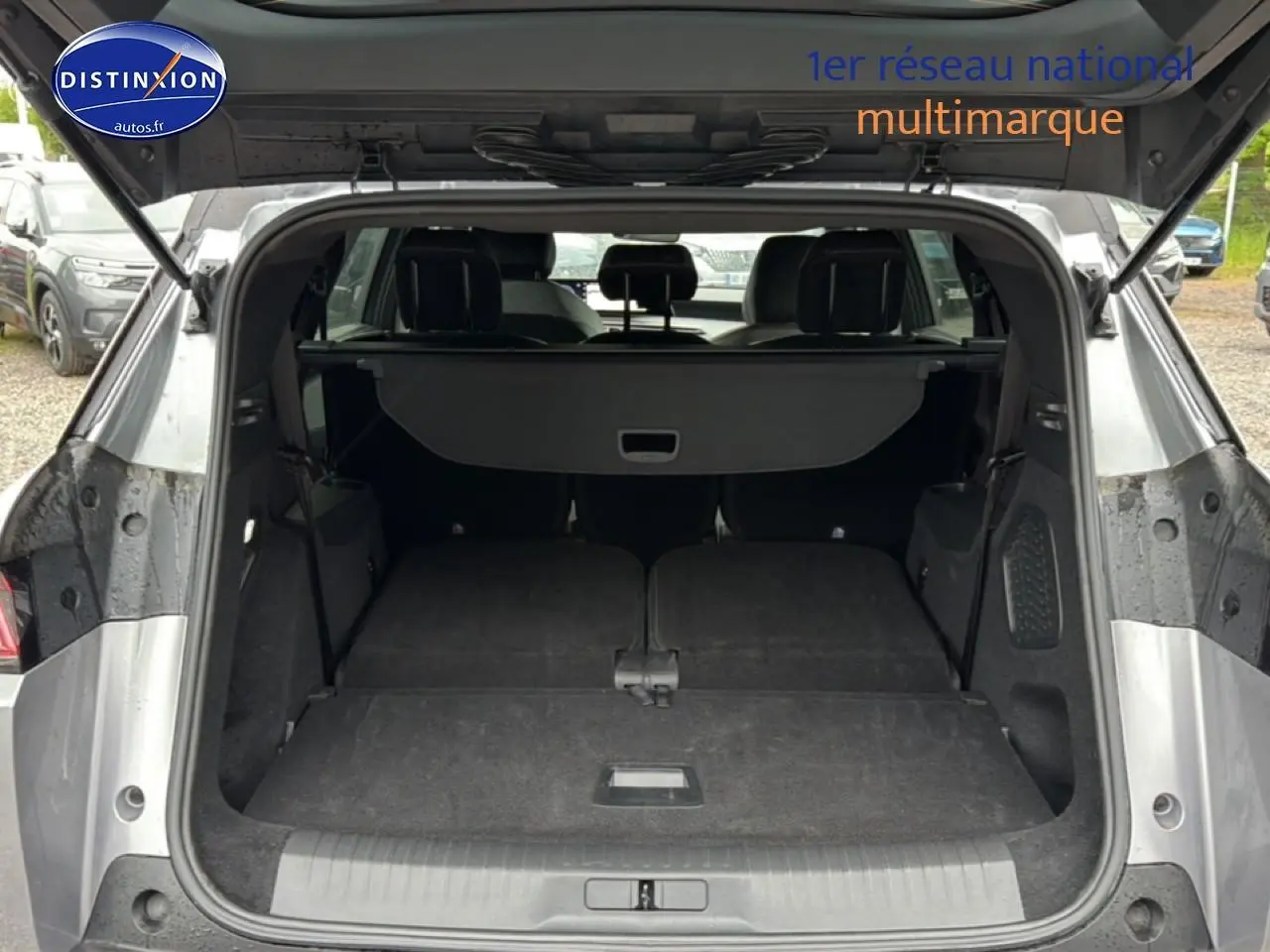 Coffre ouvert vu de l'arrière d'un Peugeot 5008 gris artense avec banquette arrière rabattue à plat.