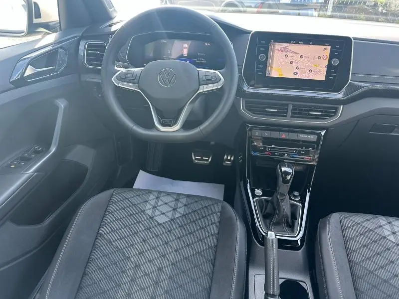 Vue intérieure avant du Volkswagen T-Cross 1.0 TSI R-Line 2026, volant cuir multifonction et écran tactile GPS.