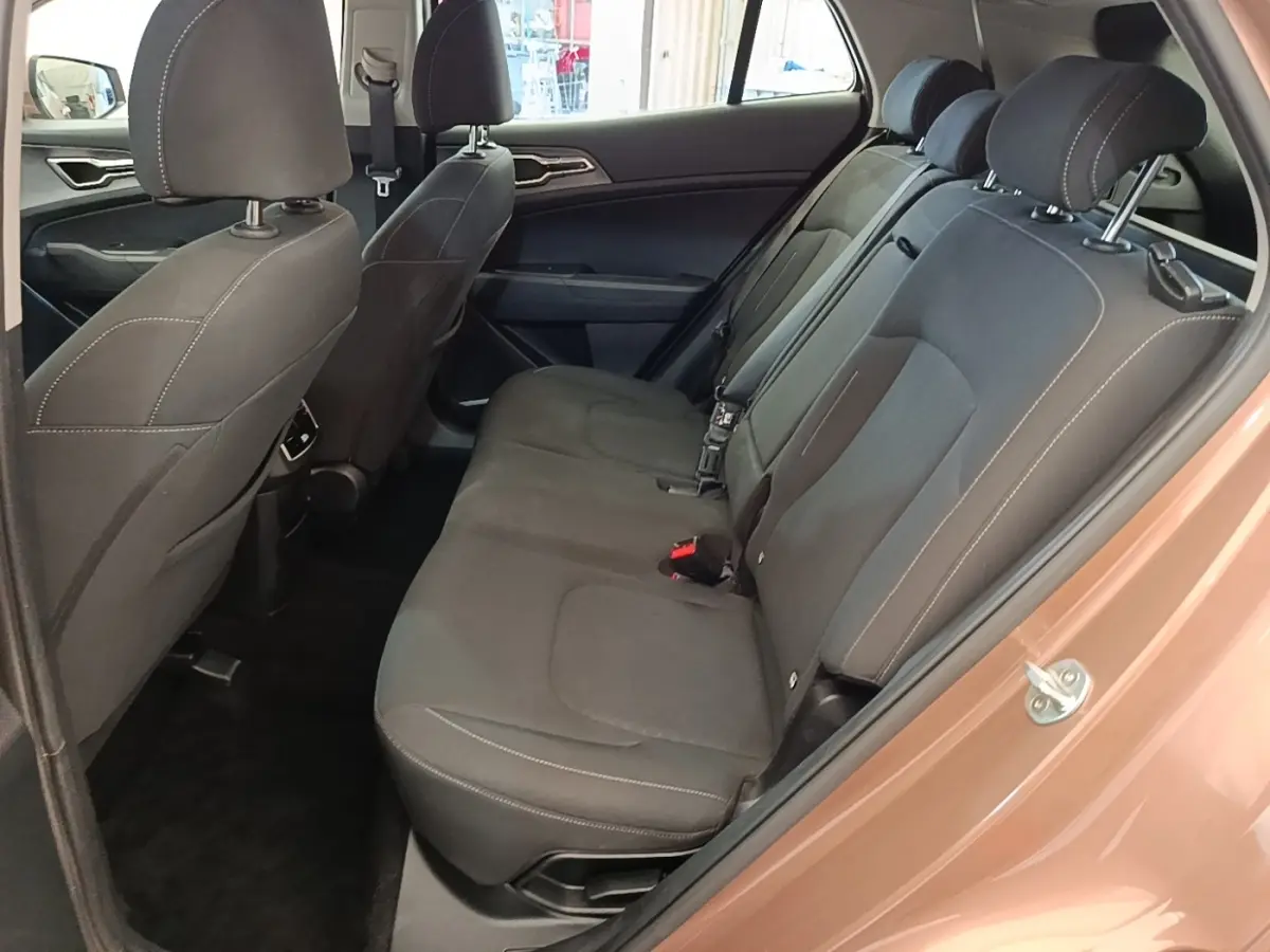 Vue intérieure côté droit sur la banquette arrière noire du Kia Sportage beige 2022, avec appuie-têtes et ceintures visibles.