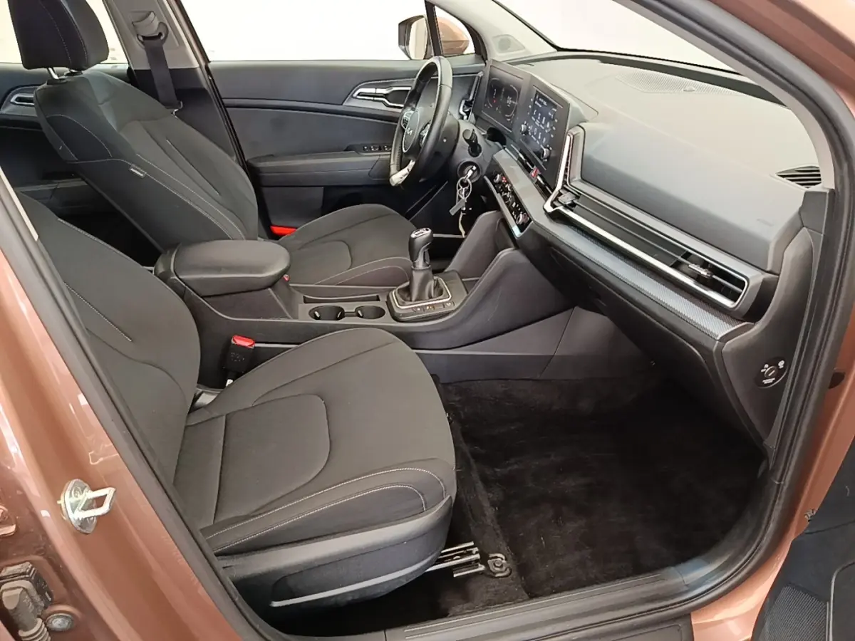 Vue intérieure côté passager avant du Kia Sportage beige 2022, montrant sièges noirs et tableau de bord moderne.