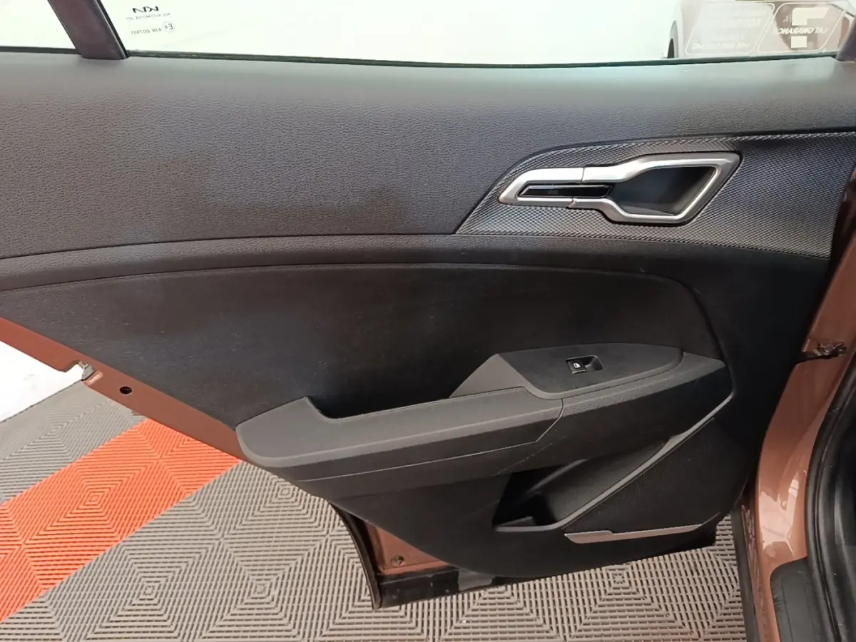Vue rapprochée de la porte arrière gauche beige du Kia Sportage 2022, avec poignée intérieure chromée et panneau noir.