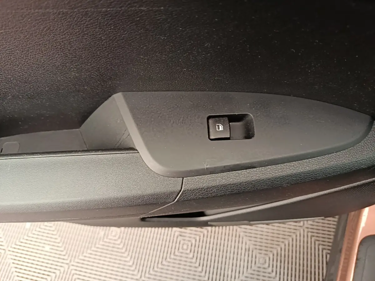 Détail de la commande de verrouillage de porte sur la portière côté conducteur d’un KIA Sportage beige 2022.